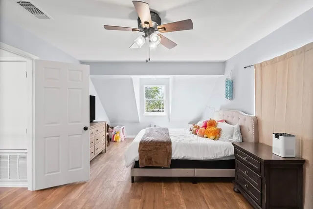 a bedroom with a bed and wooden floor
