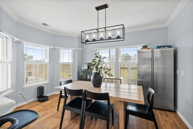a dining room with furniture a chandelier and wooden floor