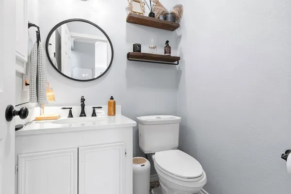 a bathroom with a toilet a sink and a mirror