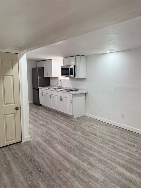 244 Wilbur Street, Unit 3 Fall River, MA 02724 - Photo 7 of 21 a room with kitchen island stainless steel appliances a sink and a refrigerator
