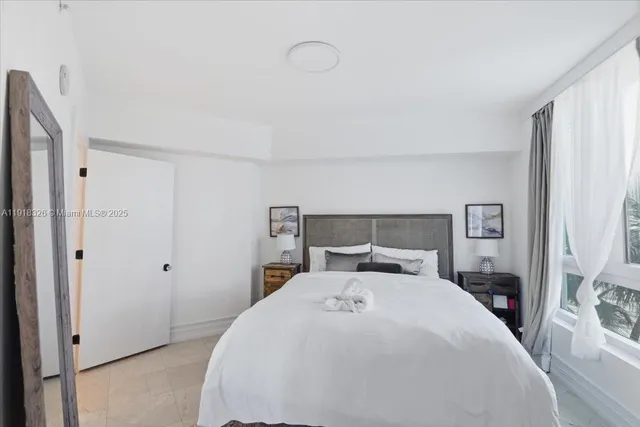 a bedroom with a bed and a large mirror