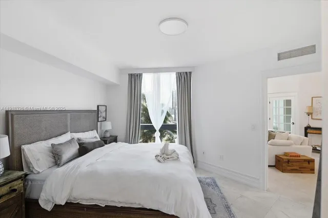 a bedroom with a bed and a large window