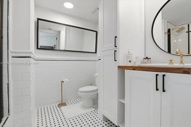 a bathroom with a sink toilet a mirror and vanity