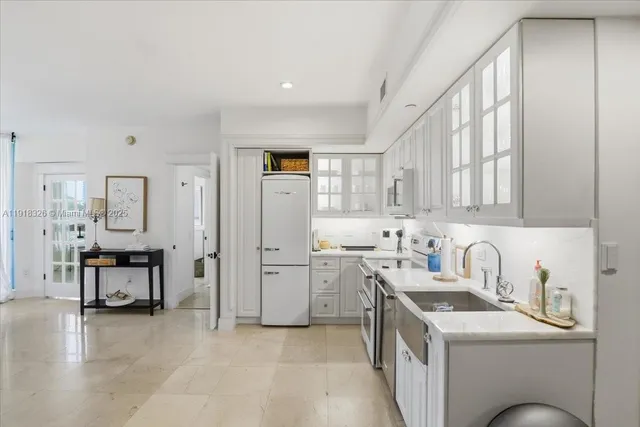 a kitchen that has a lot of cabinets in it and wooden floors
