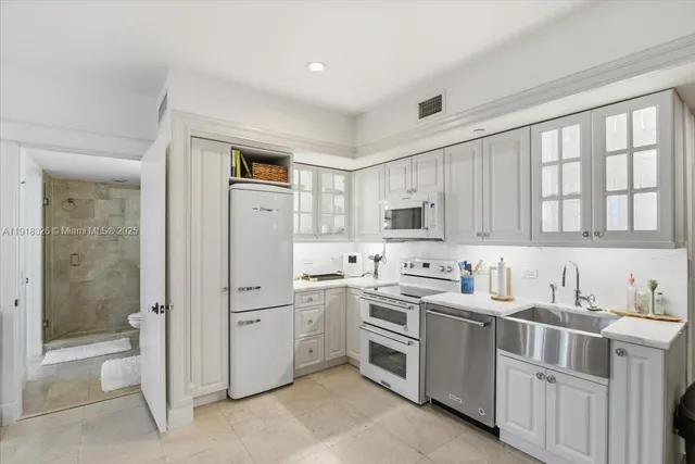 a kitchen with white cabinets and white appliances