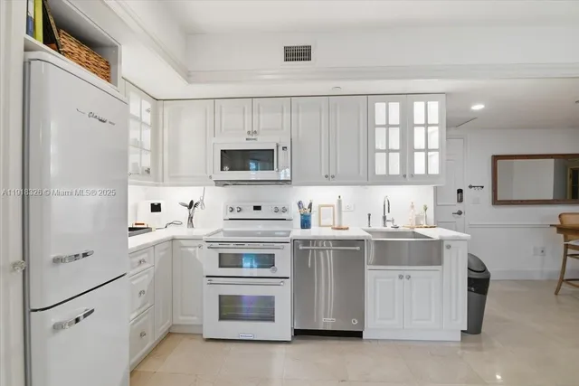 a kitchen with white cabinets and white appliances