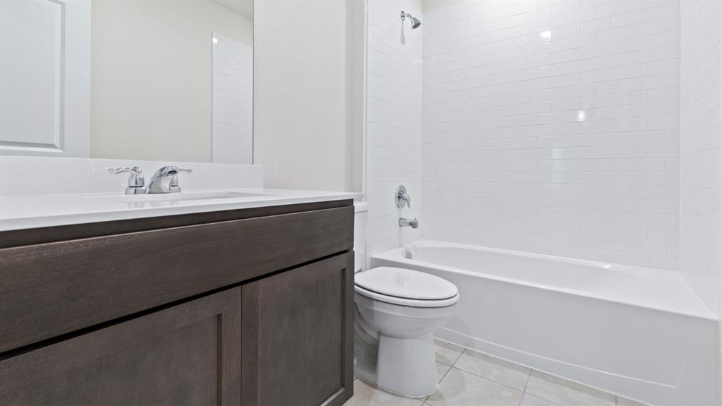 4028 Ripplewood Drive Lindale, TX 75771 - Photo 2 of 31 White ceramic subway tile surround with a built-in tub and shower
