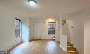 an empty room with wooden floor and entryway