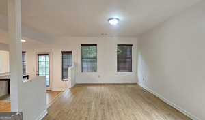 5851 Giles Road Lithonia, GA 30058 - Photo 3 of 15 an empty room with wooden floor and windows