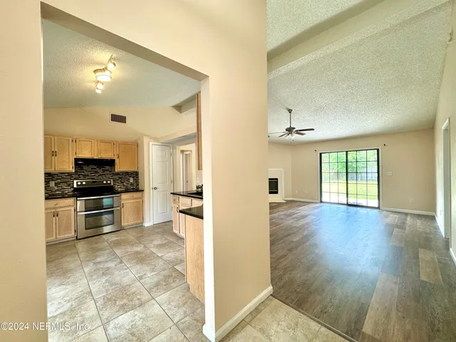 a view of kitchen with microwave a stove and cabinets