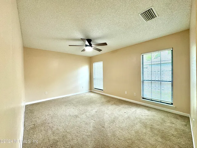 an empty room with windows and closet