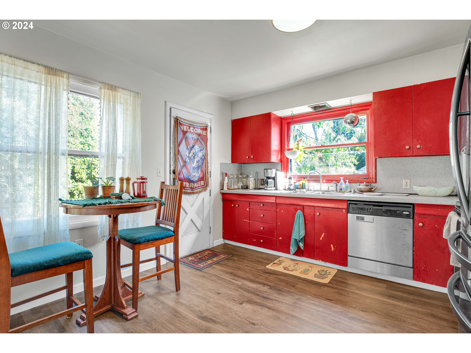 1315 North Russet Street Portland, OR 97217 - Photo 6 of 21 a kitchen with stainless steel appliances kitchen island granite countertop a table chairs in it and wooden floors