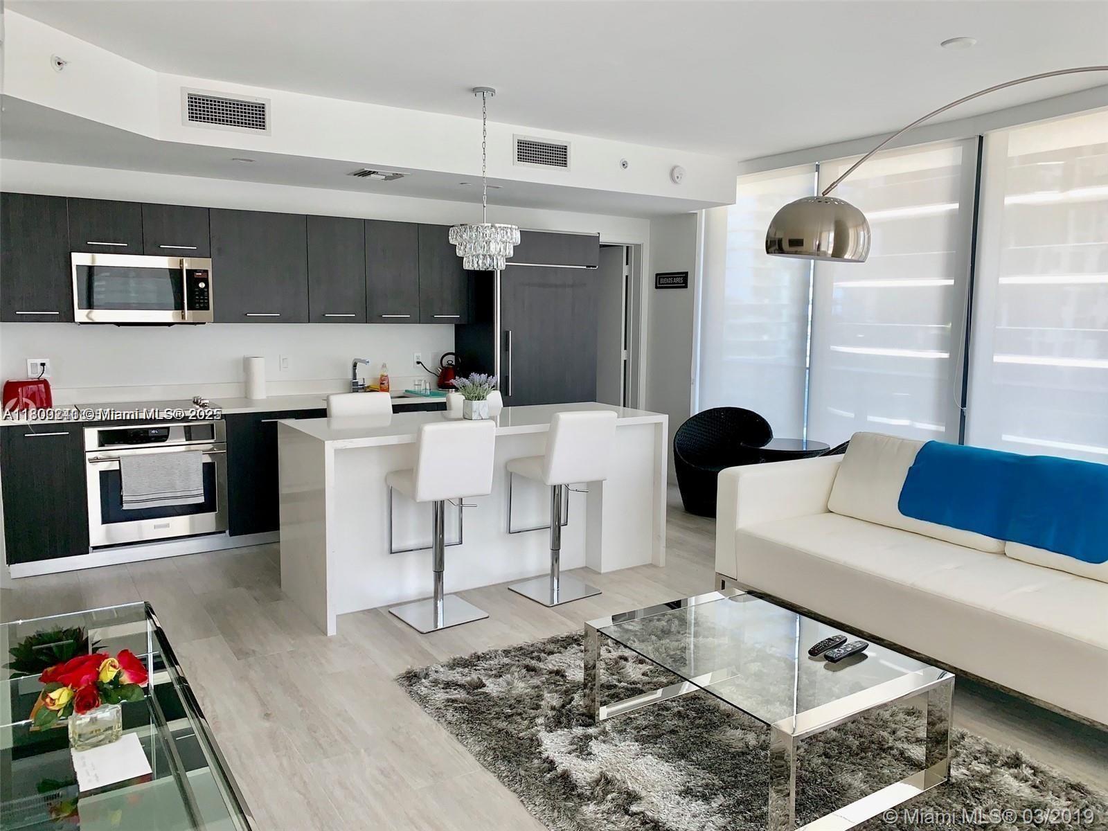 55 Southwest 9th Street, Unit 2003 Miami, FL 33130 - Photo 7 of 8 a living room with stainless steel appliances furniture and a rug