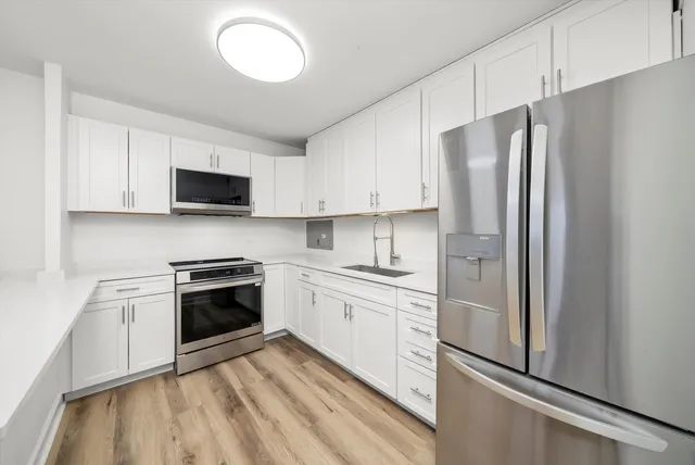 a kitchen with stainless steel appliances granite countertop a refrigerator sink and stove