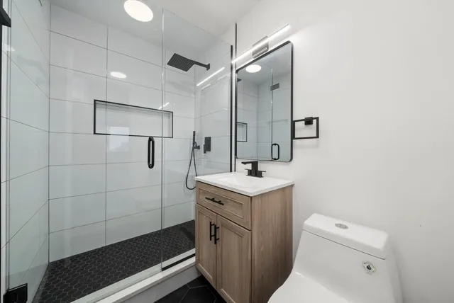a bathroom with a sink a toilet and shower
