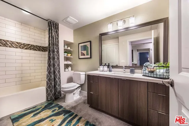 a bathroom with a double vanity sink toilet and shower