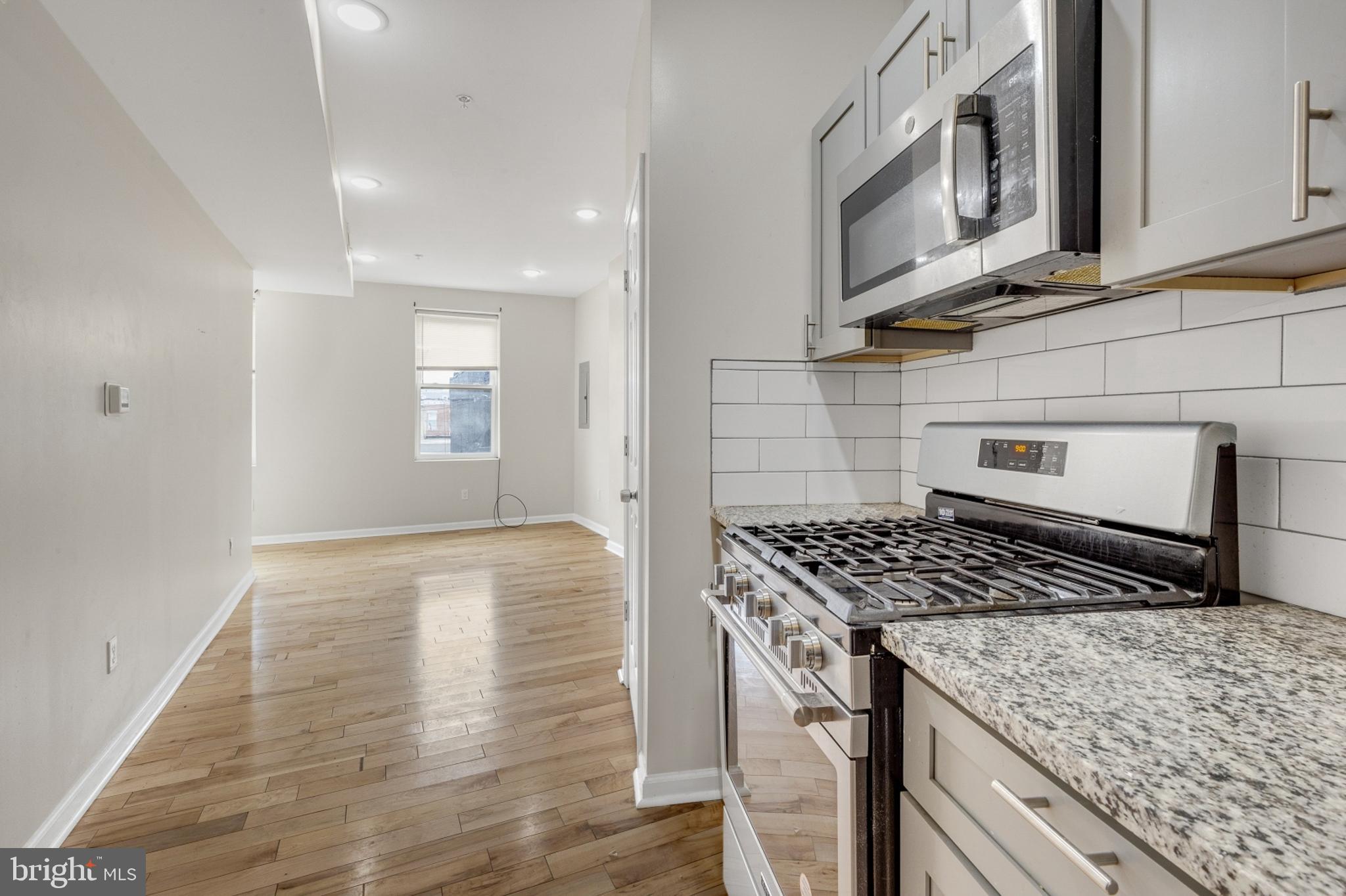 2604 Frankford Avenue, Unit 3 Philadelphia, PA 19125 - Photo 3 of 13 a kitchen with stainless steel appliances granite countertop a stove a sink and a microwave