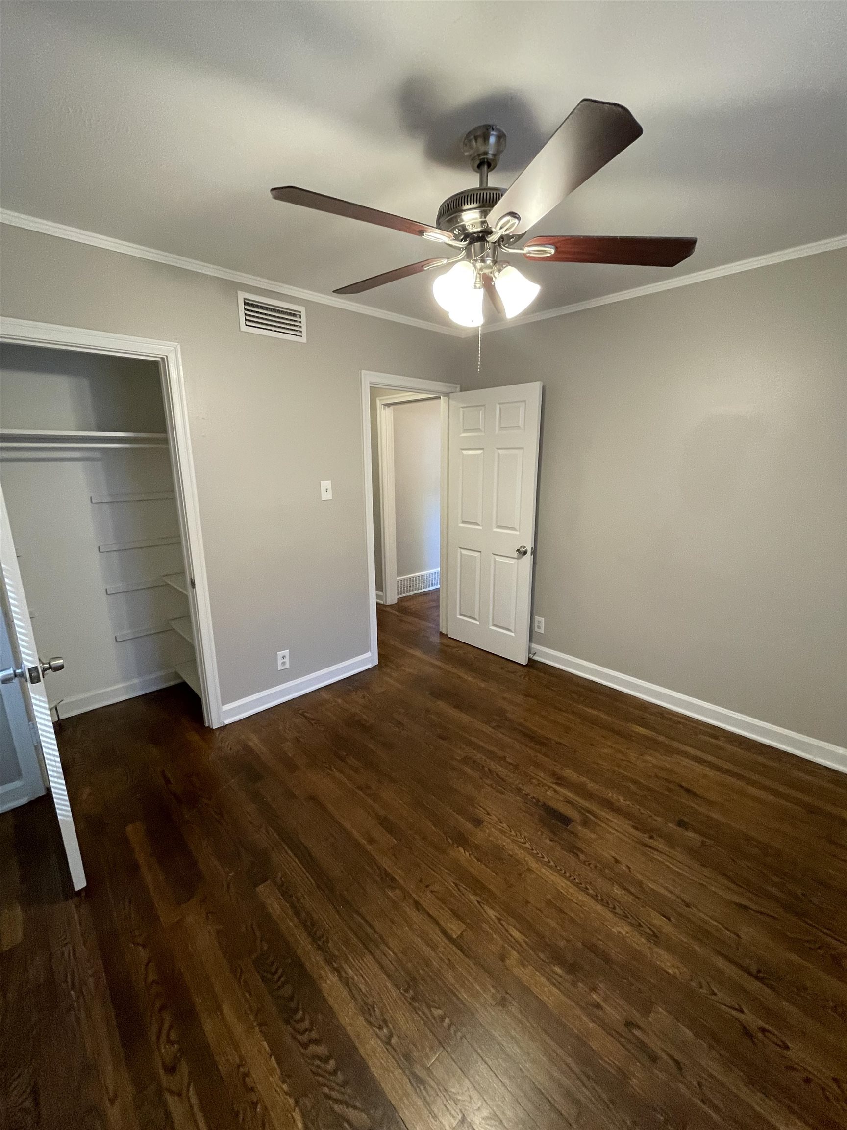 1451 Titus Road Memphis, TN 38111 - Photo 4 of 11 a view of an empty room with wooden floor and a ceiling fan