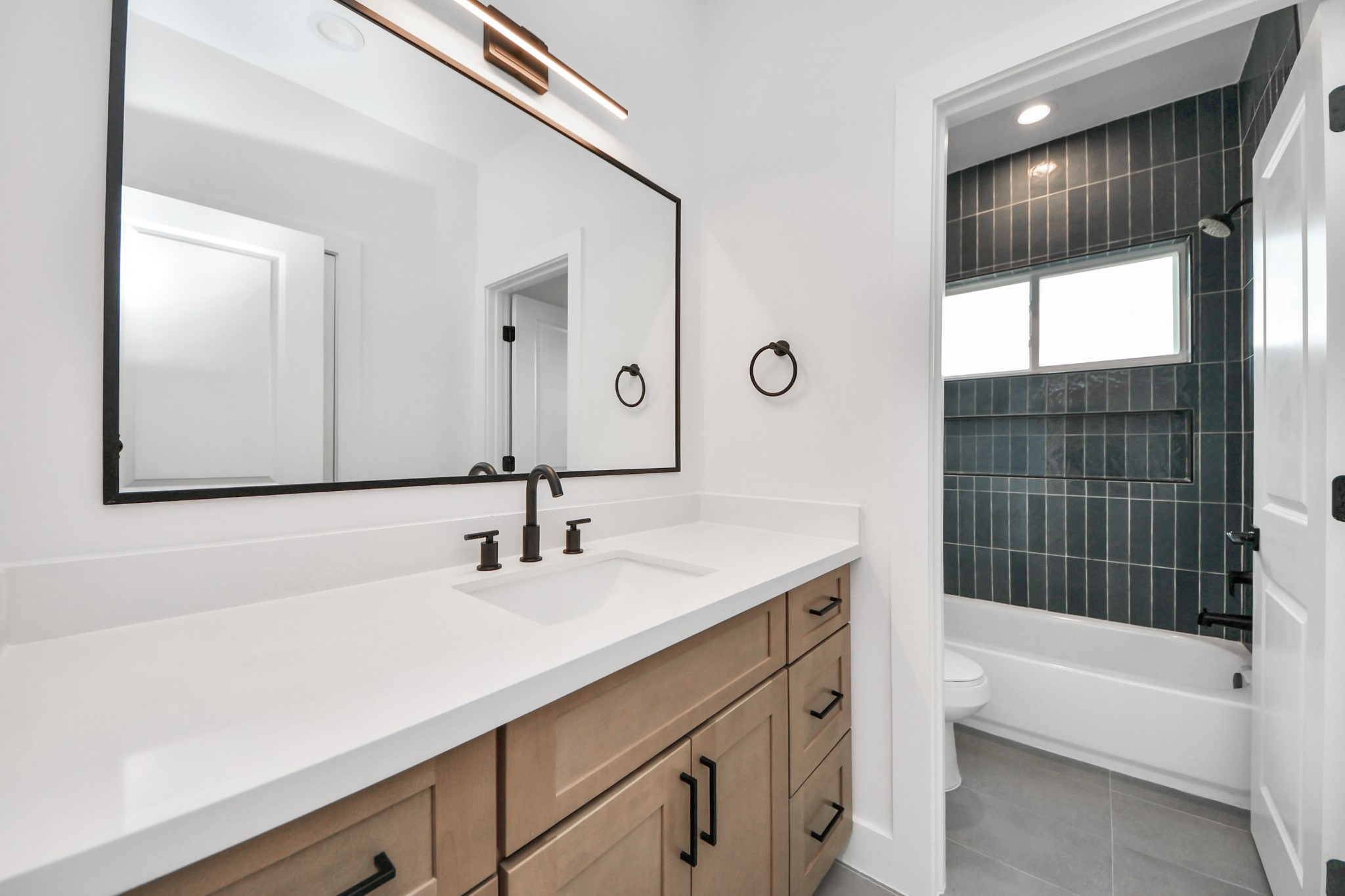 505 Middle Street Houston, TX 77003 - Photo 36 of 46 Discover the elegance of a sleek, modern third full bathroom, featuring a spacious double vanity and a chic, tiled shower/bathtub combo, perfect for both guests and family.