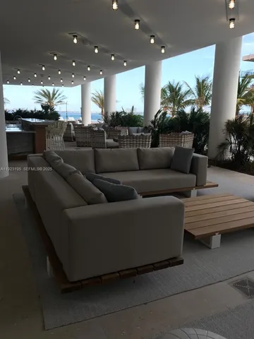 a living room with furniture and a view of kitchen