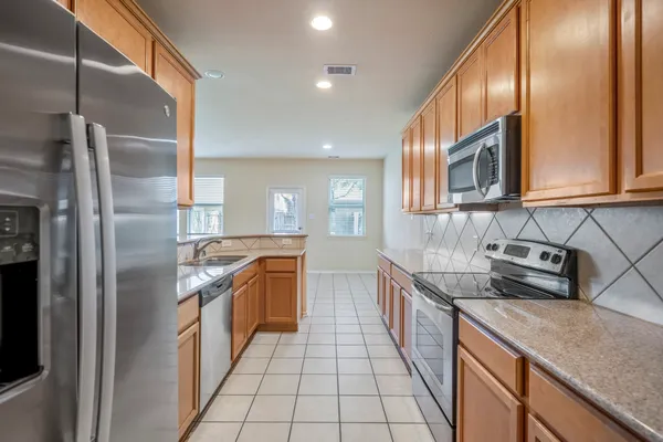 a kitchen with stainless steel appliances granite countertop a sink stove and refrigerator