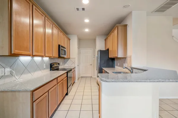 a kitchen with stainless steel appliances granite countertop a sink a stove and cabinets