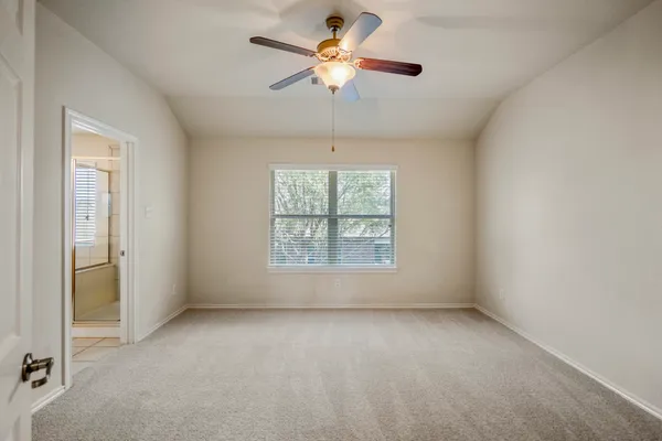 an empty room with a window and a fan