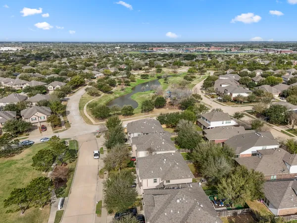 an aerial view of residential houses with outdoor space and trees
