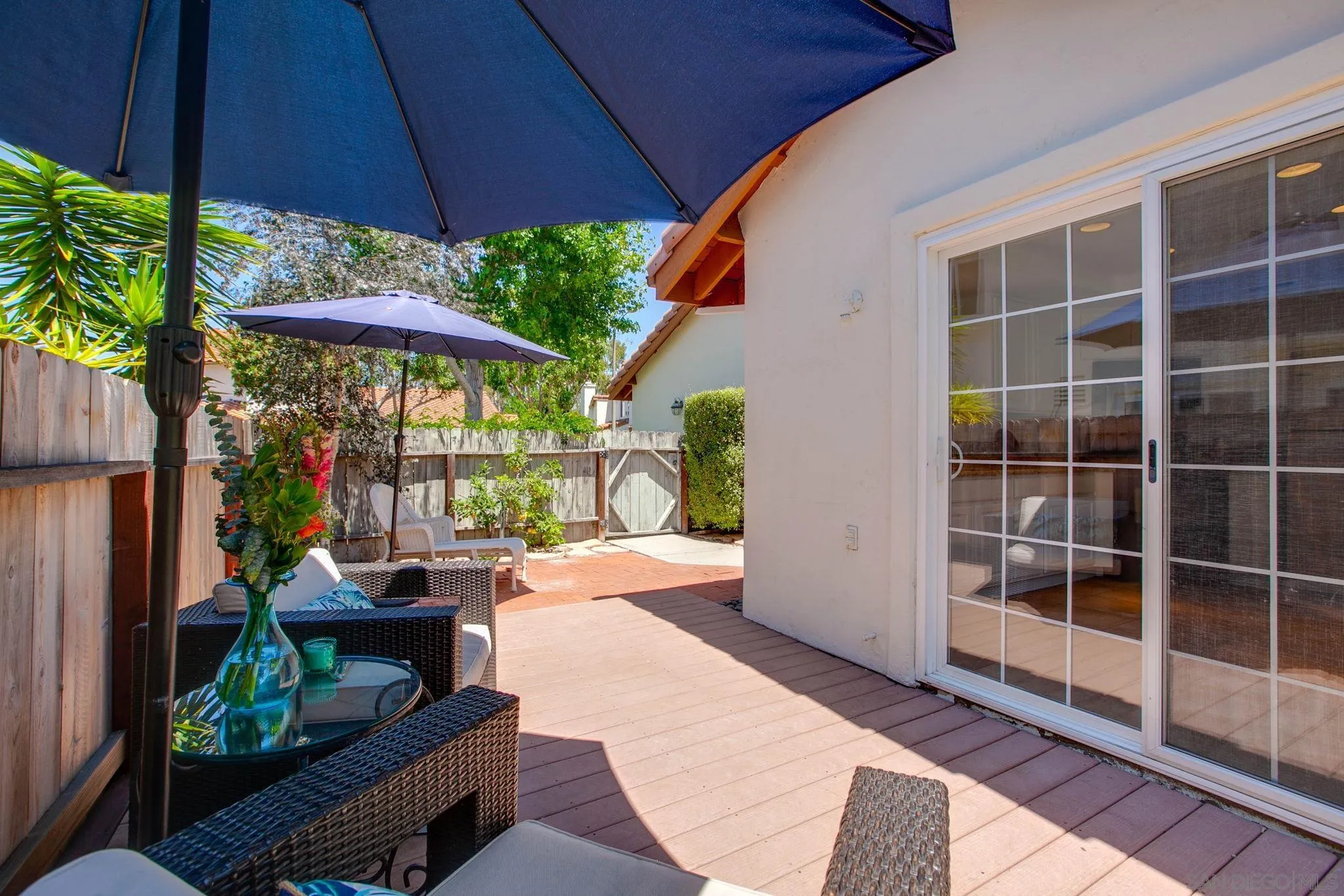 2041 Coolngreen Lane Encinitas, CA 92024 - Photo 31 of 36 a view of a patio with table and chairs potted plants and floor to ceiling window