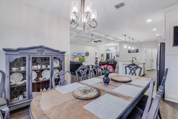 a kitchen with stainless steel appliances kitchen island granite countertop a stove a sink a refrigerator and white cabinets with wooden floor
