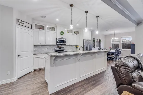 a kitchen with a sink a counter space appliances and cabinets