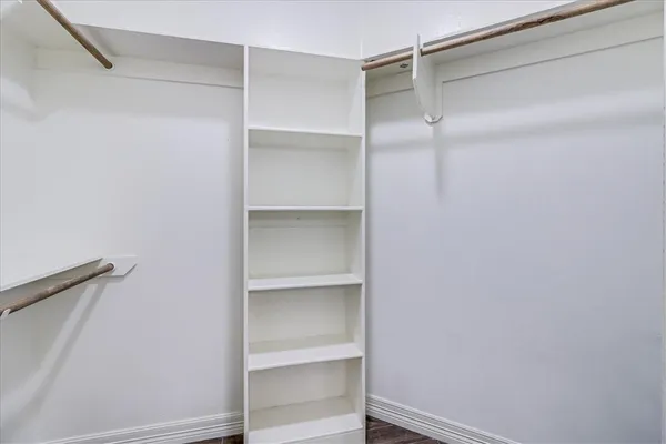 a view of walk in closet with empty racks
