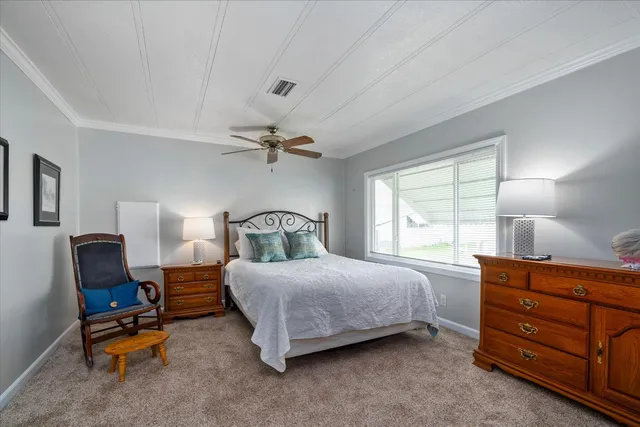a bedroom with a bed a lamp and a large window