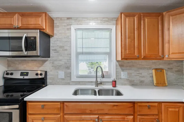 a kitchen with stainless steel appliances granite countertop a sink and a microwave