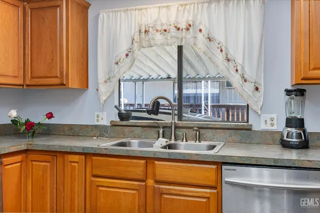 a kitchen with stainless steel appliances granite countertop a sink dishwasher and cabinets with wooden floor