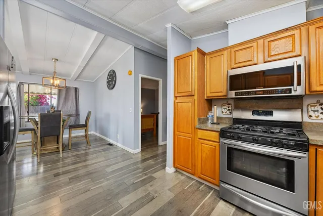 a kitchen with stainless steel appliances a stove a microwave and wooden floors