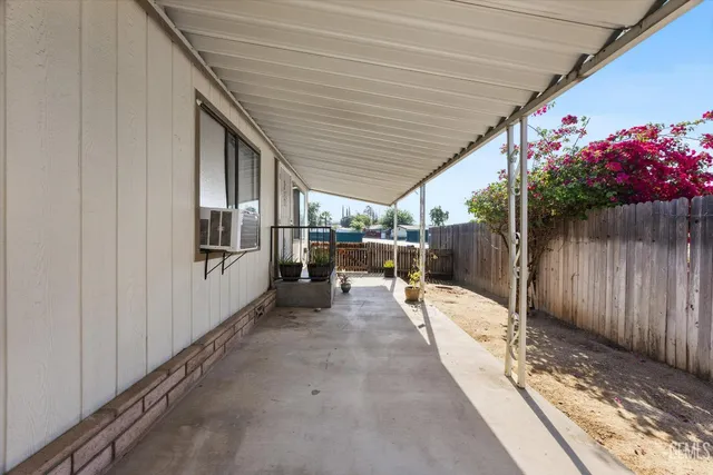 a patio with table and chairs and potted plants