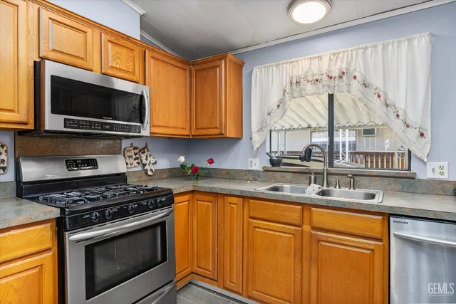 a kitchen with stainless steel appliances granite countertop a stove a sink and a microwave