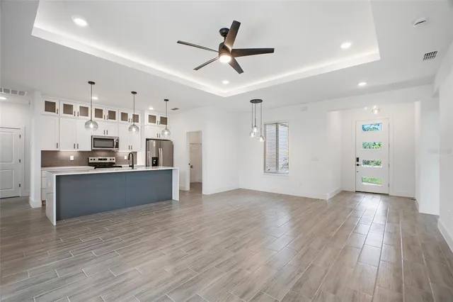 a view of kitchen with stainless steel appliances refrigerator stove microwave and cabinets