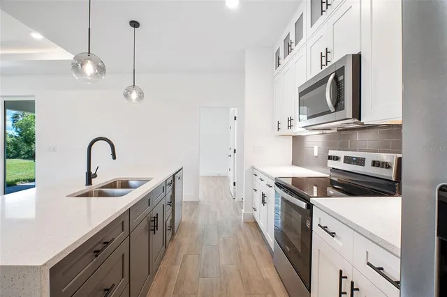 a kitchen with stainless steel appliances granite countertop a sink a stove and a refrigerator