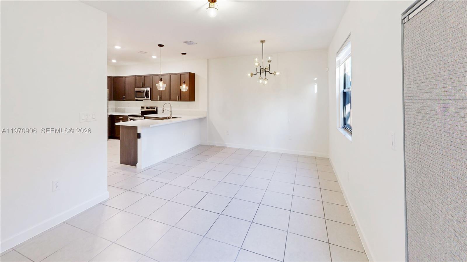 13158 Southwest 233rd Street Homestead, FL 33032 - Photo 14 of 72 a kitchen with stainless steel appliances a refrigerator and a stove top oven