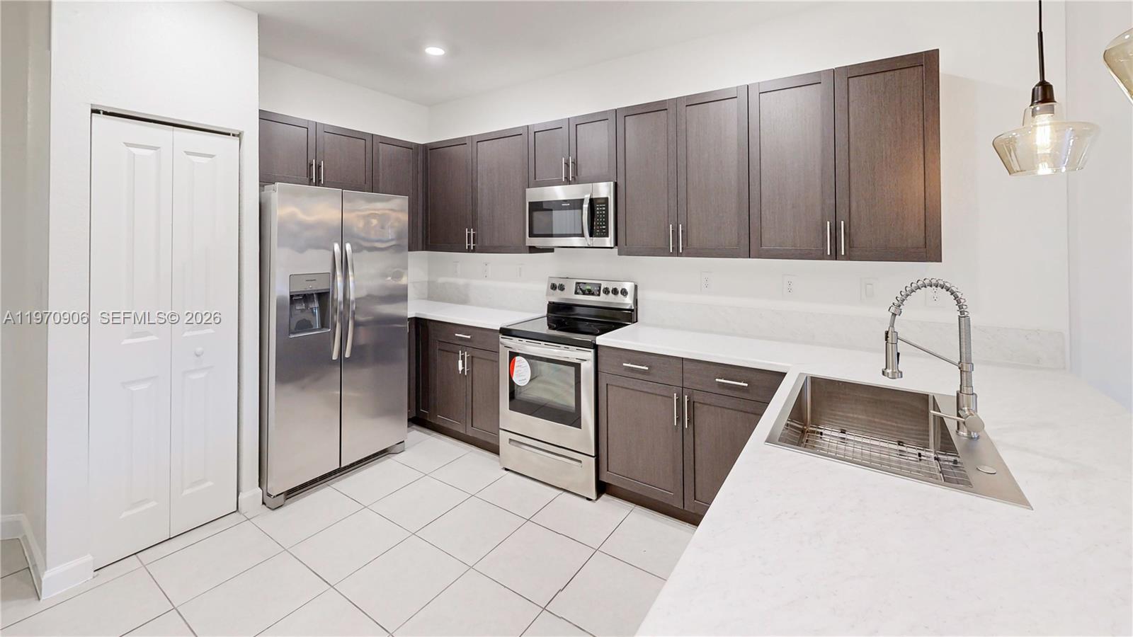 13158 Southwest 233rd Street Homestead, FL 33032 - Photo 7 of 72 a kitchen with stainless steel appliances a refrigerator sink and microwave