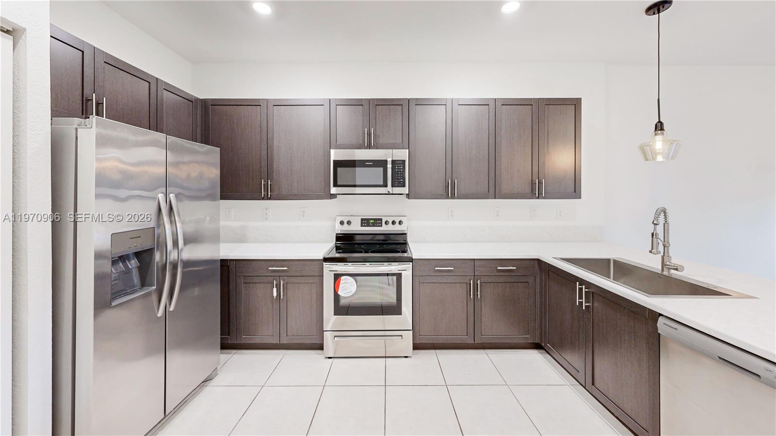 13158 Southwest 233rd Street Homestead, FL 33032 - Photo 8 of 72 a kitchen with stainless steel appliances a refrigerator sink and microwave