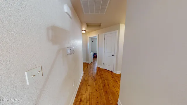 a view of a hallway with wooden floor and closet