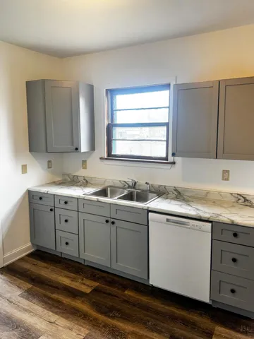 a kitchen with granite countertop cabinets sink and window