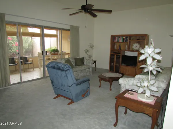 a living room with furniture a fireplace and a floor to ceiling window