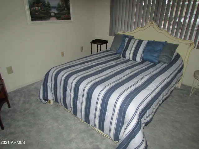 a bedroom with a bed and painting on the wall