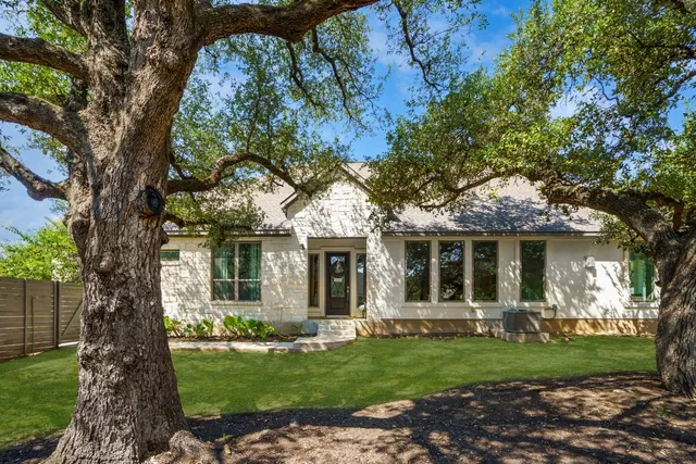 a view of a house with backyard and a tree