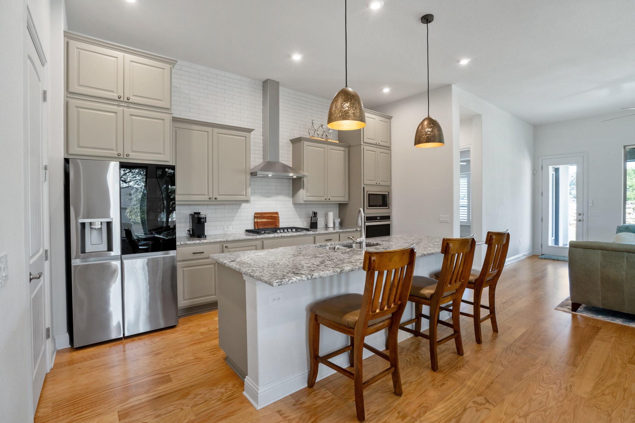 224 Diamondback Drive Georgetown, TX 78628 - Photo 8 of 39 a kitchen with stainless steel appliances kitchen island granite countertop a table chairs and a refrigerator