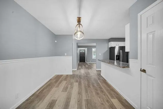 a view of a hallway with wooden floor and staircase